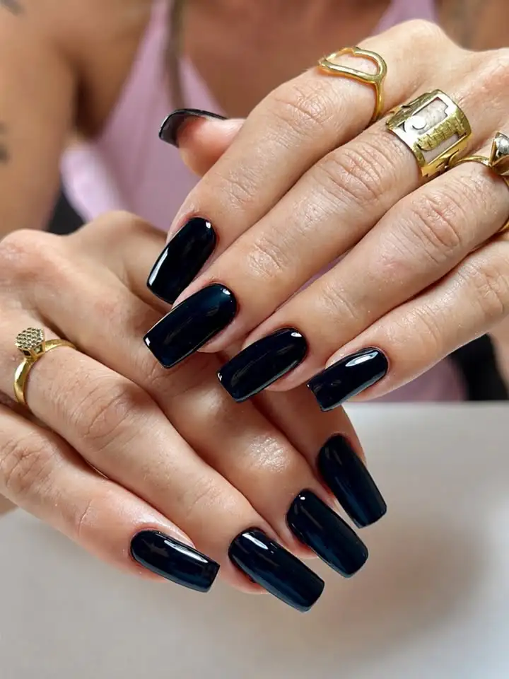 Unhas esmaltadas em tom bordô profundo com filete dourado luxo